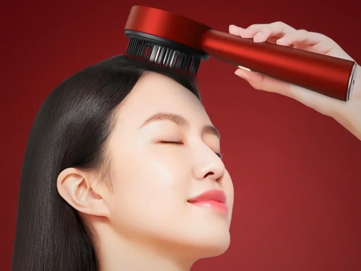 Mujer usando el masajeador capilar con luz roja